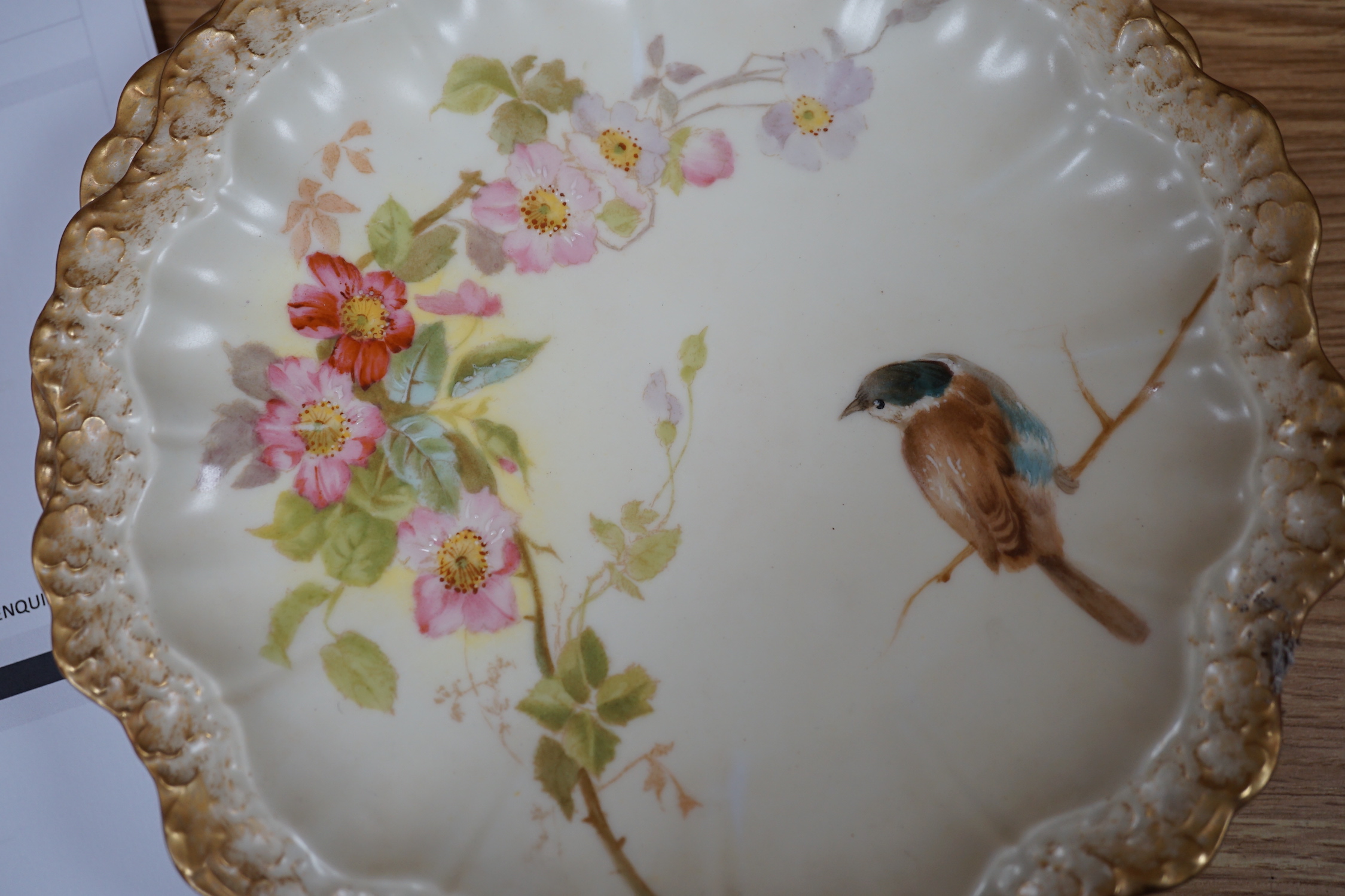 A Limoges dessert service decorated with birds and flowers, the largest 27cm wide